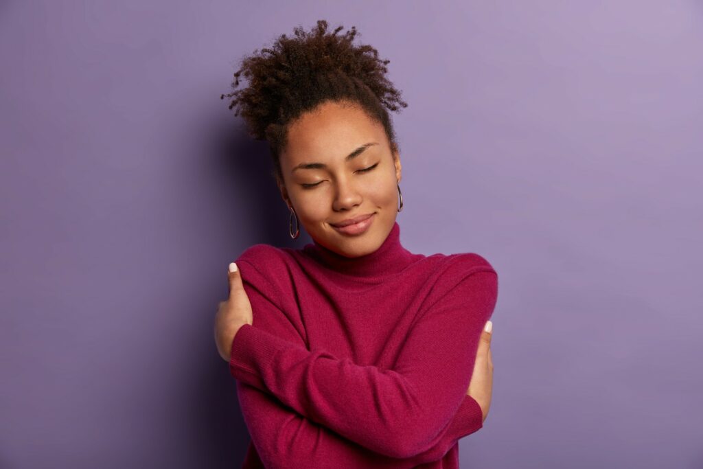 black woman hugging herself