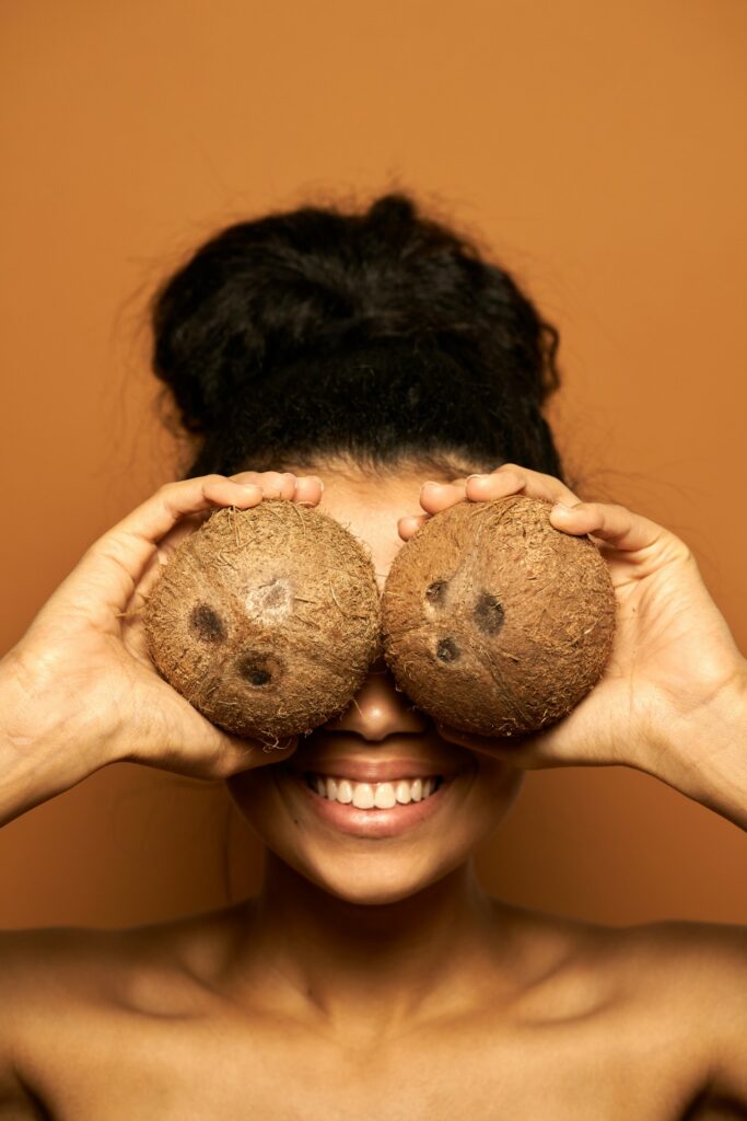 black woman using coconut oil in skincare